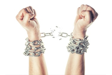 Two hands breaking free from chains around the wrists