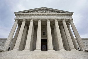 On the steps of the Supreme Court of the United States, looking up at the towering columns