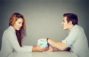 Couple fighting over piggy bank and assets during divorce