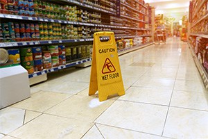 Concept photo for personal injury caused by negligence of a wet floor sign in a grocery store aisle